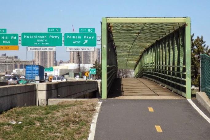 greenway going through bridge with street signs