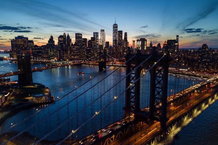 icon new york city bridge at dusk with city skyline and water